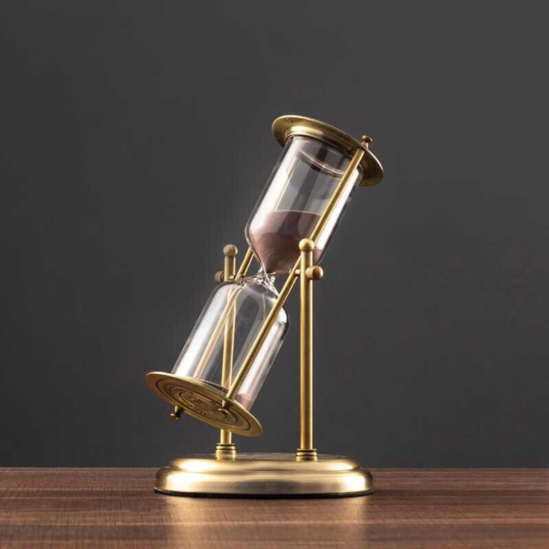 Antique hourglass made of brass with violet sand