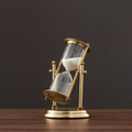 Antique hourglass made of brass with violet sand