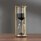 Antique hourglass made of brass with violet sand