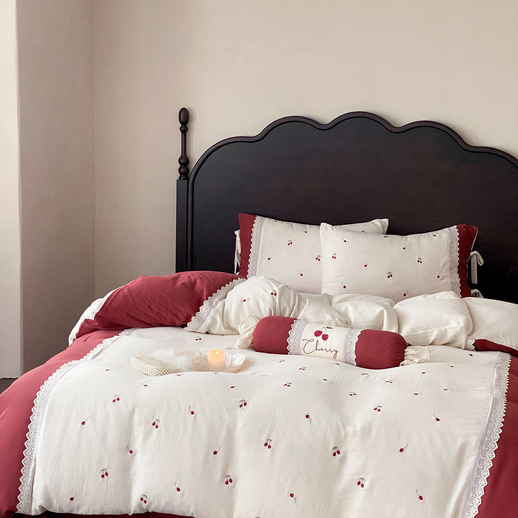 Country-style bedding set with cherry embroidery, lace trim, and decorative neck roll