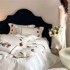 Embroidered cotton satin bedding set with floral applications and decorative border