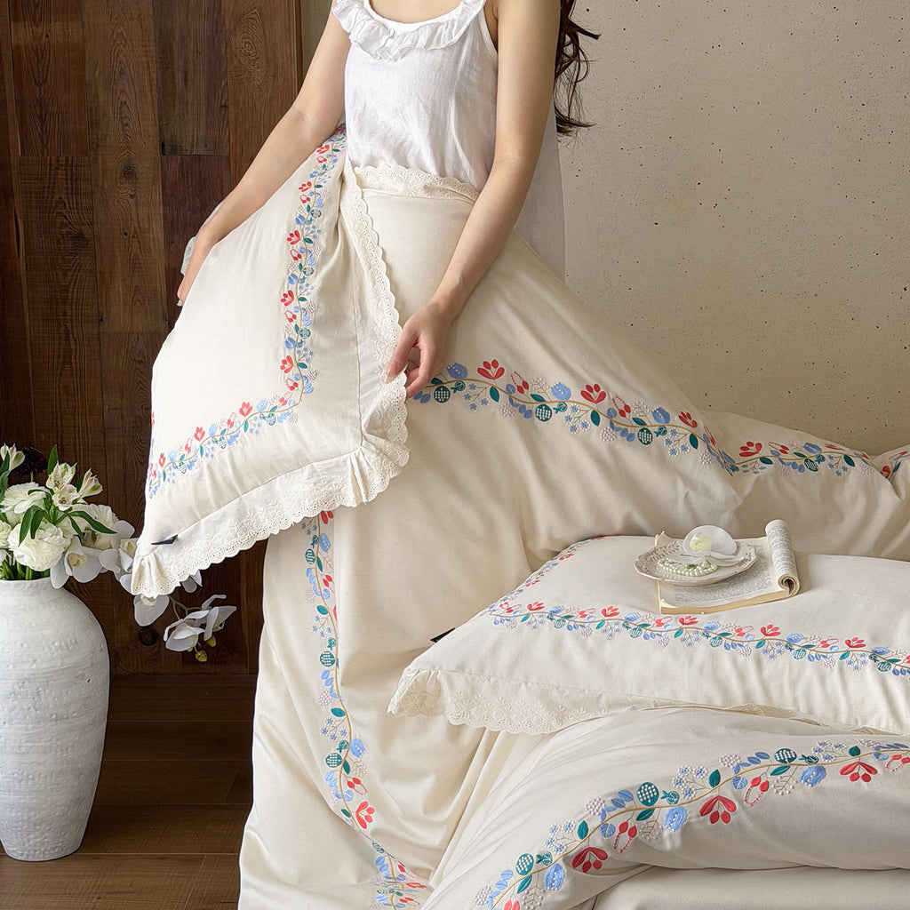 Embroidered cotton satin bed linen set with floral border and fine lace edge