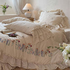 Romantic linen-cotton bedding set with embroidered floral border and ruffle