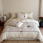 Luxurious cotton satin duvet cover set with lace trim, floral all-over embroidery, and decorative ribbons