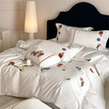 Embroidered cotton satin bedding set with floral applications and decorative border