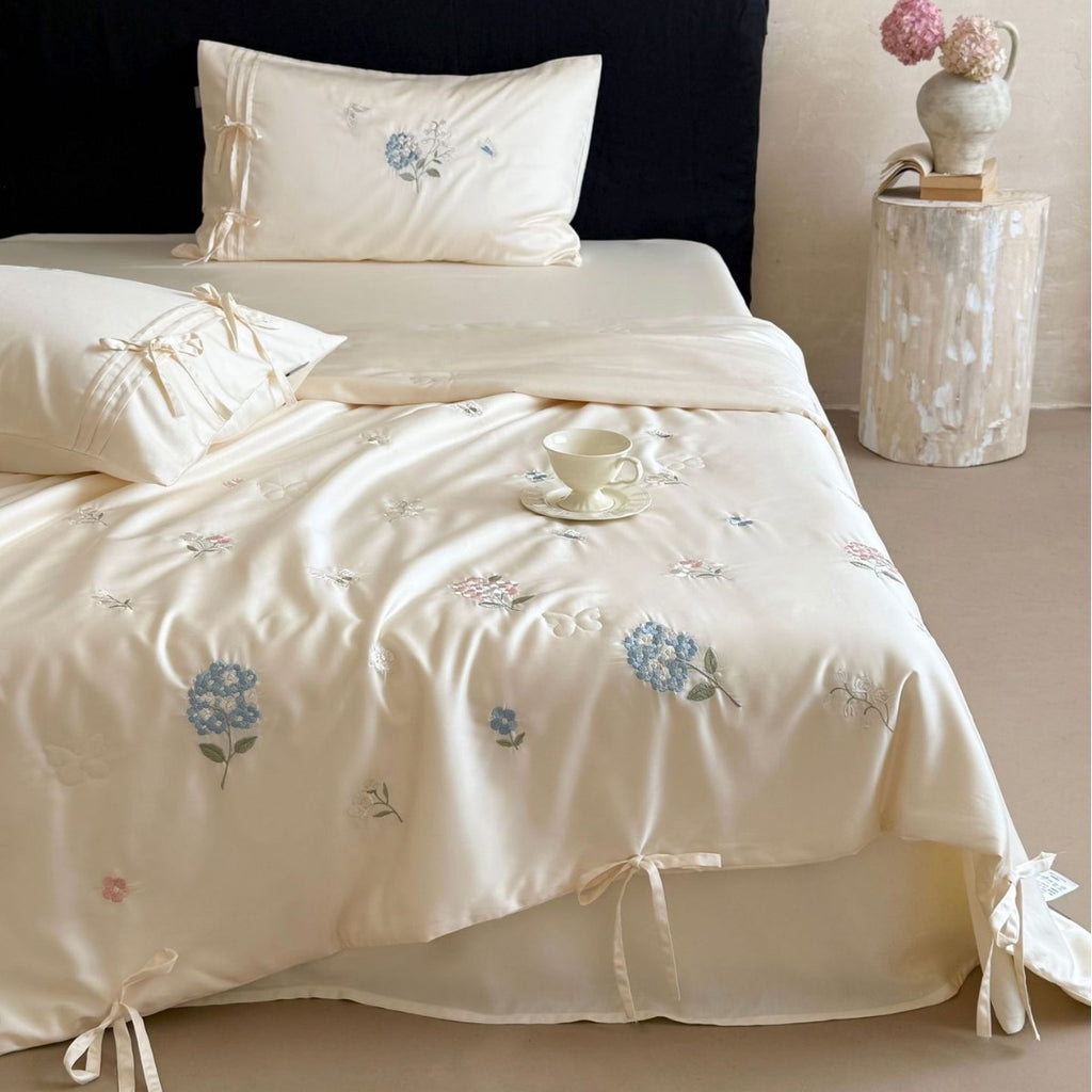 Satin bedding set with floral embroidery, tie ribbons, and silky glossy finish