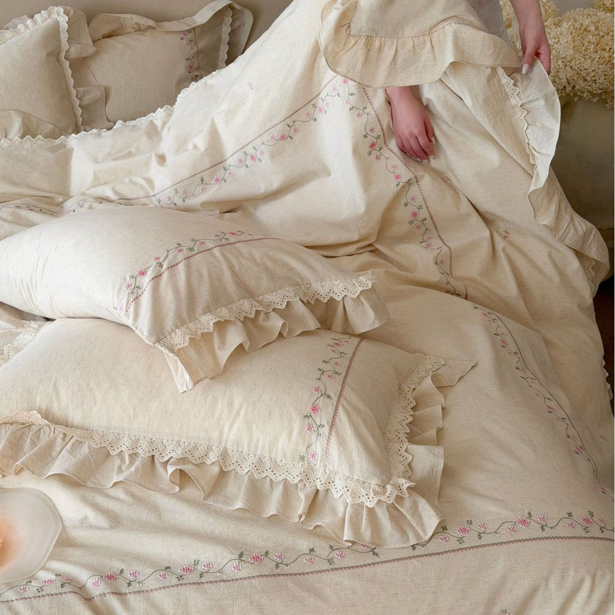 Vintage-inspired cotton bedding set with ruffles, delicate floral embroidery, and lace trim