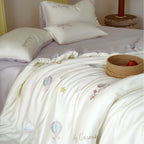 Premium children's bedding set made of cotton satin with pastel-embroidered balloon and carousel motifs.