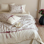 Luxurious cotton satin duvet cover set with lace trim, floral all-over embroidery, and decorative ribbons