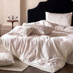 Luxurious satin bedding set with floral embroidery and butterfly appliqué