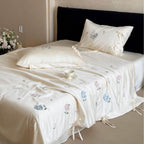 Satin bedding set with floral embroidery, tie ribbons, and silky glossy finish